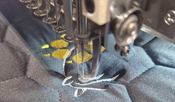 Machine à broder réalisant une broderie personnalisée sur tapis d’équitation – Cap Horse Ornex